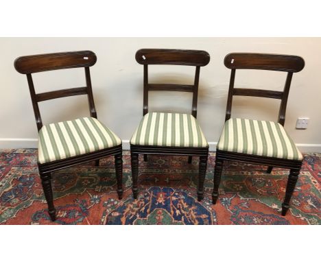 A set of three Regency mahogany bar back dining chairs with upholstered seats on turned front legs, a 19th Century Chippendal