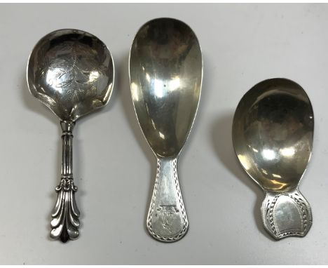 A Georgian Irish silver caddy spoon with bright cut decorated handle and armorial of a greyhound's head and crown, a Victoria