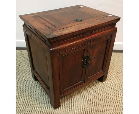 A 19th Century Chinese elm dwarf cupboard, the top with rising compartment over two panelled doors, raised on scroll feet, 53
