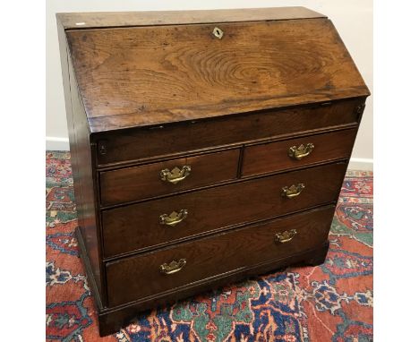 An 18th Century oak bureau, the plain top above a plain sloping fall enclosing a fitted interior with pigeonholes, drawers an