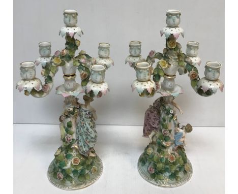 A pair of circa 1900 Sitzendorf table candelabra, five light, four branch on figural decorated columns with floral and foliat