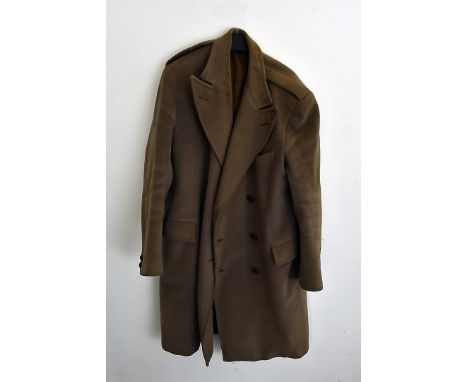 A collection of military formal wear and vintage clothing, including a greatcoat, a green waterproof over coat, trousers, wai