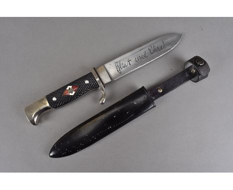 A Nazi Hitler Youth dagger, having criss cross hand grip, with enamel plaque with swastika design, leading to an engraved bla