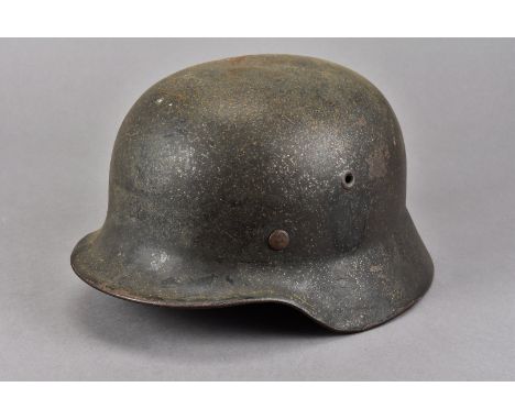 A German Army M35 single decal helmet, having single faded shield to one side, with leather liner and chin strap, possibly re