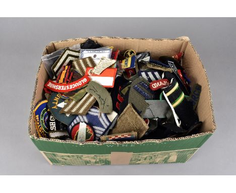 An extensive assortment of British and Overseas cloth badges and epaulettes, including Royal Army Service Corps, Merchant Nav