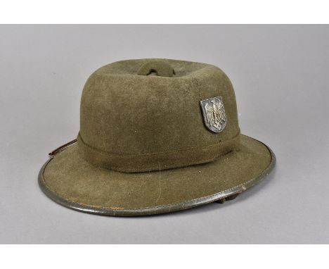 A WWII Third Reich Afrika Korps Pith helmet, in olive green, with German Army metal decal to one side and Eagle and Swastika 