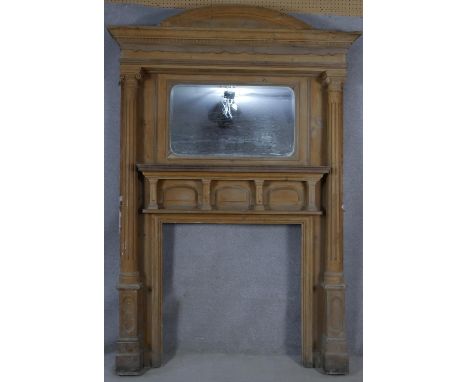 A large 19th century pitch pine fire surround and overmantel with architectural pediment above bevelled mirror flanked by car