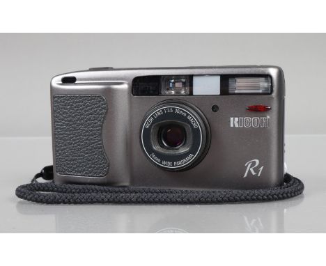 A Ricoh R1 Compact Camera, powers up, shutter working, flash working, self timer working, body G-VG, elements G-VG, with wris