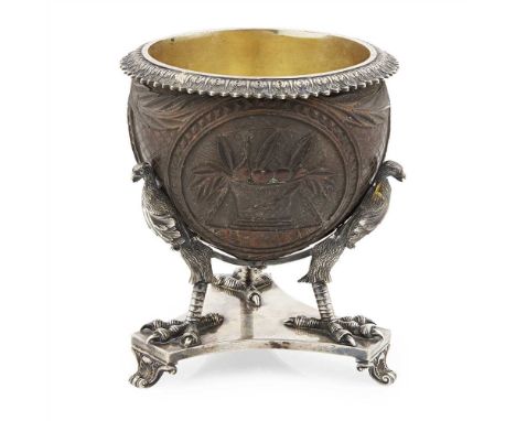 A George III silver mounted carved coconut cup Robert Hennell, London 1827, the coconut carved with three ovals of plants, ba