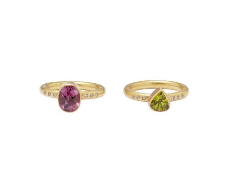 A set of two gem set stacking rings the first collet set with an oval-cut pink tourmaline, the shoulders each gypsy set with 
