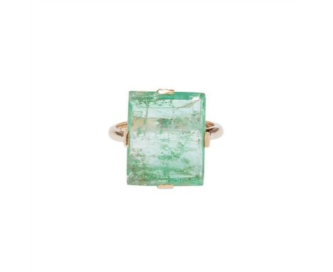 An emerald set ring claw set with a rectangular polished emerald slice, to a plain yellow metal shank with indistinct marks (