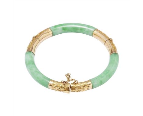 A jade set bangle of double hinged design, the yellow gold mounts with embossed detail, clasp stamped P.C 18 (Dimensions: Int