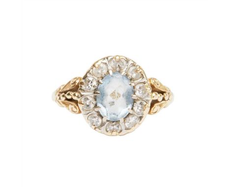 An aquamarine and diamond set cluster ring claw set with an oval-cut aquamarine in a border of round brilliant-cut diamonds, 