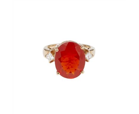 A fire opal and diamond set ring claw set with a large oval-cut fire-opal, flanked to either side by a princess-cut diamond, 