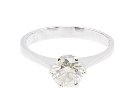 A single stone diamond set ring claw set with a round brilliant-cut diamond, to a plain white metal shank stamped 750 (Dimens