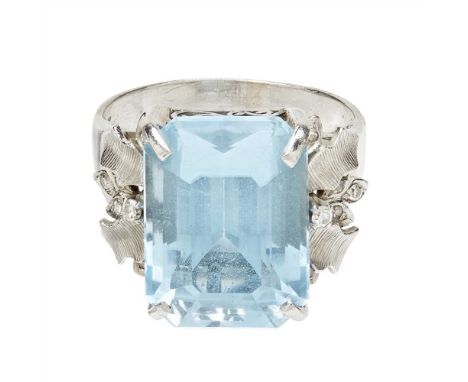 A topaz and diamond set cocktail ring claw set with a large emerald-cut blue topaz, the foliate shoulders set with eight-cut 