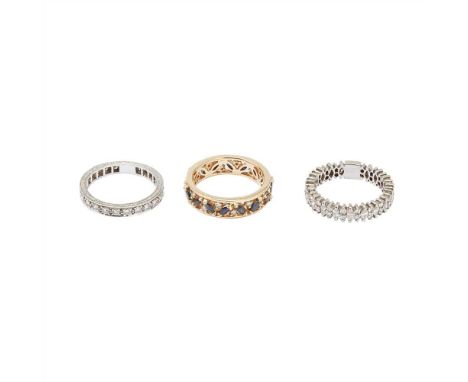 A collection of three eternity rings to include a platinum and diamond set eternity ring, composed of a continuous row of rou