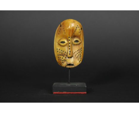 African Congolese 'Lega' bone sharm in the shape of a mask with the typical Lega characteristics || AFRIKA /KONGO  -  20° EEU
