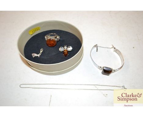 A silver and amber mounted ring, bracelet and charm 