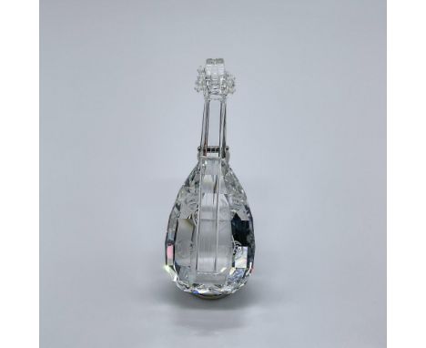 This musical figure is made from clear crystal, and it comes with a rhodium stand. This item has its original box measuring 3