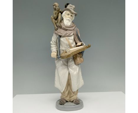 Glossy finish. Figure of an elderly man with a monkey on his shoulder, holding a musical instrument. Lladro backstamp. Artist