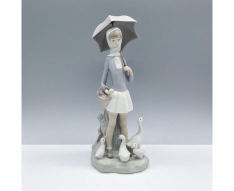 Matte porcelain depiction of an adorable girl holding an umbrella as she is surrounded by a flock of ducks. Lladro backstamp.