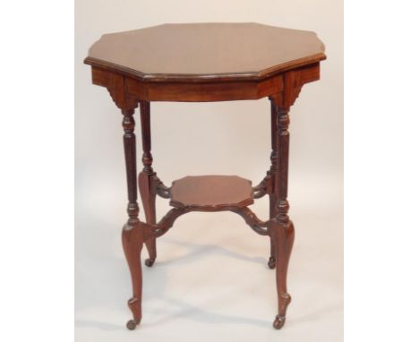 An Edwardian mahogany two tier occasional table, the shaped octagonal top on reeded turned supports with canted square under 