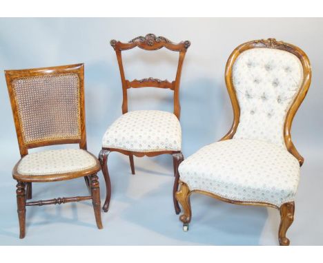 A Victorian mahogany spoonback nursing chair, with buttonback, serpentine front upon cabriole legs, terminating on ceramic ca