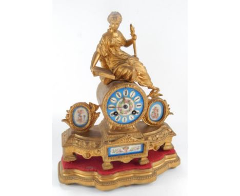 An ormolu style mantel clock, upon plinth, surmounted by a lady with book and torch, having enamelled dial with floriate chap
