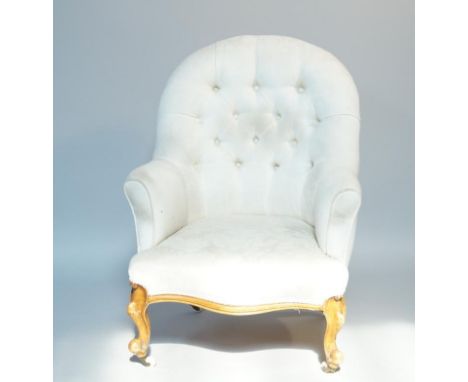A Victorian button back armchair, with button back reupholstered in cream fabric having serpentine front on ball and claw leg