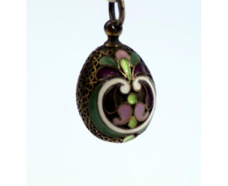 A Russian champleve egg, on green and purple ground, with filigree white purple and green enamel decoration with mark AG make