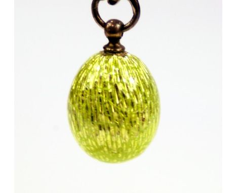 A Russian enamel egg, in plain lime green enamel decoration, with makers mark KAK with Alpha and Koloshnik facing right and 8