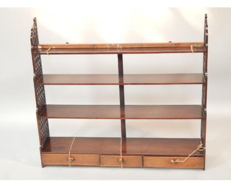 A Georgian mahogany hanging shelf rack, having Gothic style side panels graduating to base, with three inlaid drawers, 86cm h