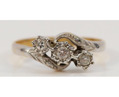 An 18ct gold and platinum three brilliant cut diamond cross over ring, P, 3g