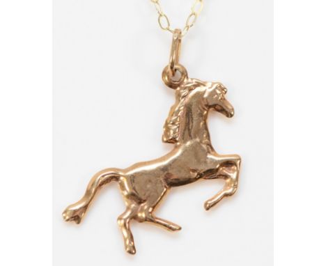 A 9ct gold horse shaped pendant on a chain, 23mm, 0.9g