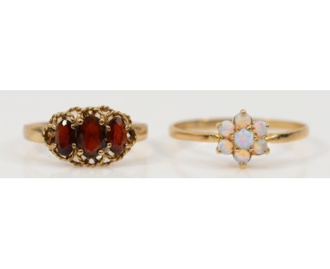 A 9ct gold garnet three stone ring, K 1/2, with a 9ct gold opal floral cluster ring, S, 3g