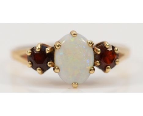 A 9ct gold opal and garnet three stone ring, 7mm x 5mm opal, O, 1.7g