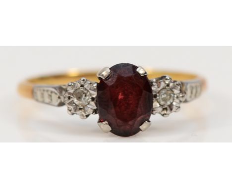 An 18ct gold and platinum garnet and diamond three stone ring, R 1/2, 3g