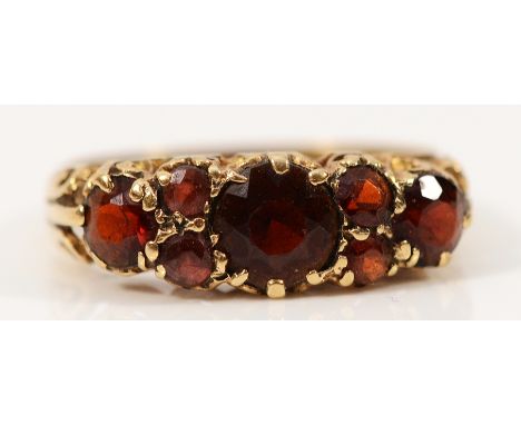 A 9ct gold garnet dress ring with carved claw detail, L, 1.8g