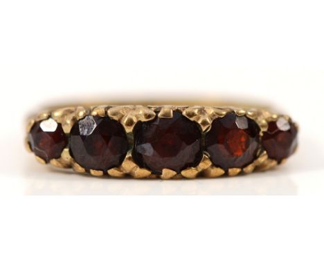 A 9ct gold garnet five stone ring, carved claw detail, Birmingham 1972, N, 2.6g