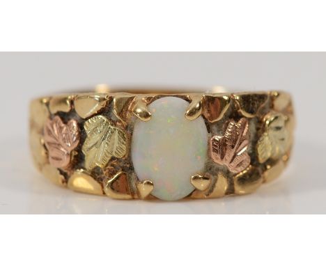 A 9ct gold opal ring, with leaf patterned shoulders, 7mm x 6mm opal, 3.7g