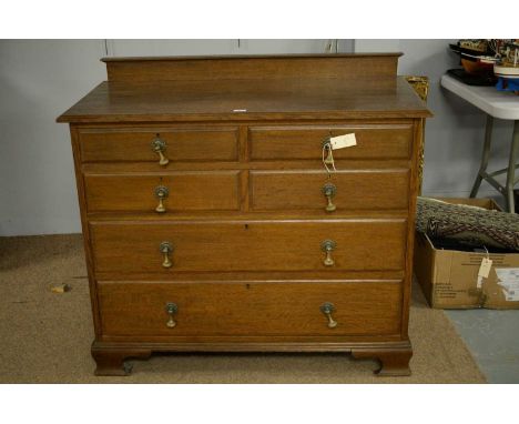 An early 20th Century oak chest of drawers, the moulded rectangular top above an arrangement of four short and two long drawe