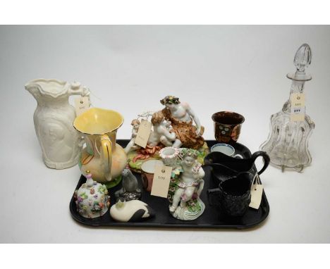 A Derby candlestick figure in the form of a putti holding a candle sconce, on scroll moulded base, patch marks; a Naples grou