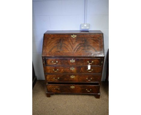 A late George III mahogany bureau, the rectangular top above a fall-front enclosing an arrangement of drawers and pigeon hole