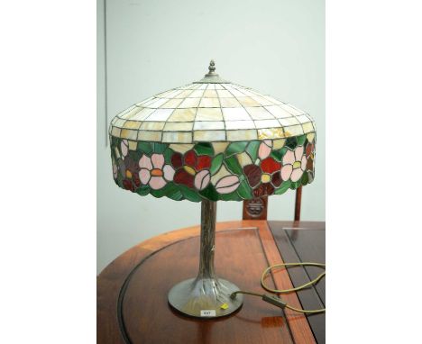 A reproduction table lamp in Tiffany style, with leaded glazed shade and silvered simulated bronze tree-shaped stand, fitted 