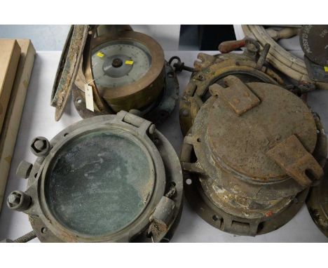 A brass cased ship's compass on a gimble and eight portholes.