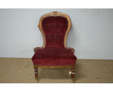 A Victorian mahogany nursing chair, with deep button back, enclosed by a carved mahogany frame above a padded seat and raised