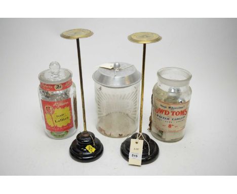 A pair of brass and black glazed ceramic weighted hat/wig stands, made for Harrods &amp; Sheldon Shopfitters, Birmingham, the