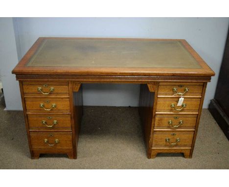 A Victorian oak desk, the rectangular top with inset green tooled leather writing surface, above two banks of four drawers, r