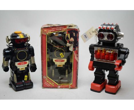 A battery-operated Tomy plastic robot, in original packaging; another Tomy robot; and another. (3)